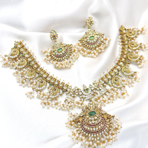 Temple peacock multicolor Kundan necklace set with green and ruby stones, pearl detailing and matching earrings by joyrias
