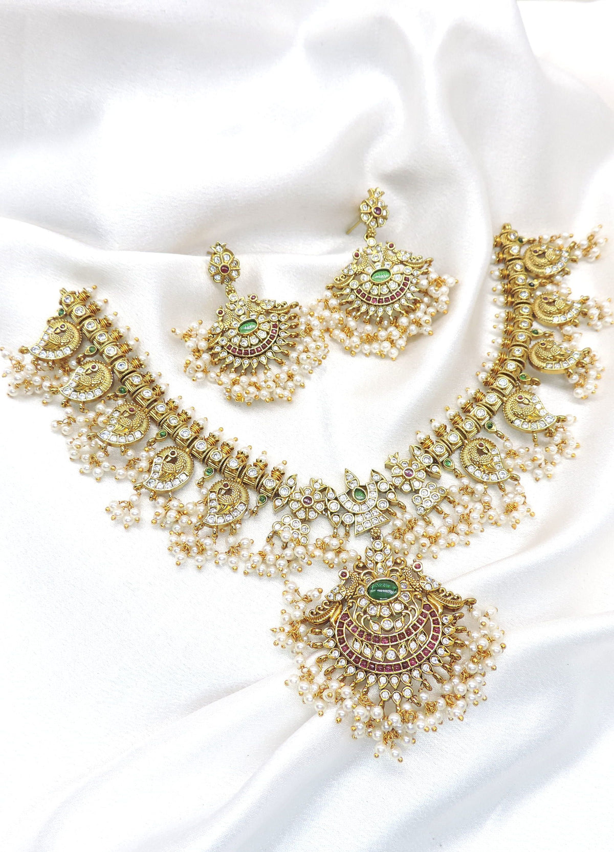 Temple peacock multicolor Kundan necklace set with green and ruby stones, pearl detailing and matching earrings by joyrias