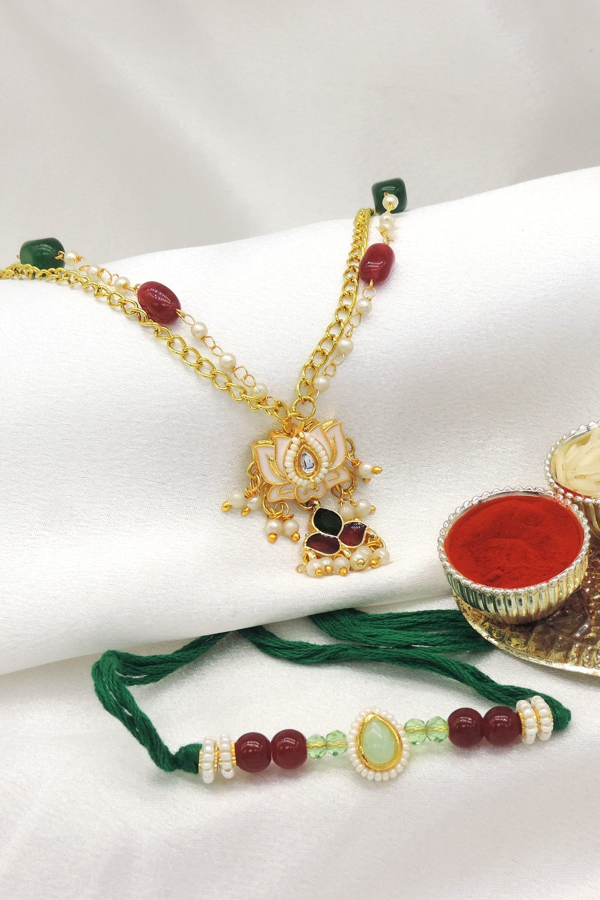 Meenakari lotus bhaiya bhabhi rakhi set with pearl drops and beaded chain by Joyrias