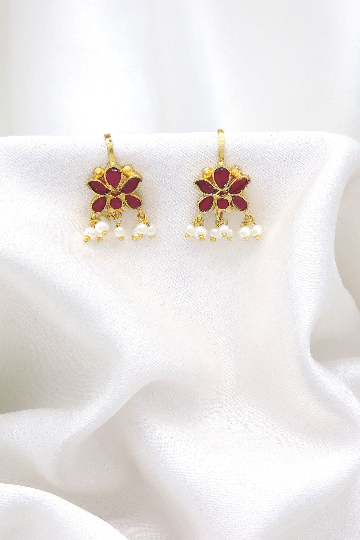 Gold-toned maroon floral pearl drop earrings with traditional detailing by joyrias