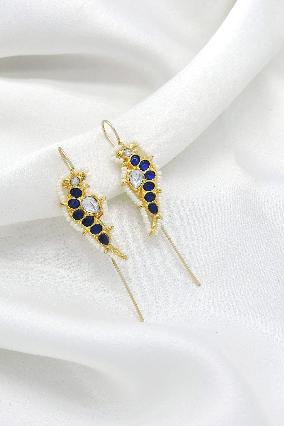 Gold-toned blue stone ear cuff earrings with white bead detailing by joyrias