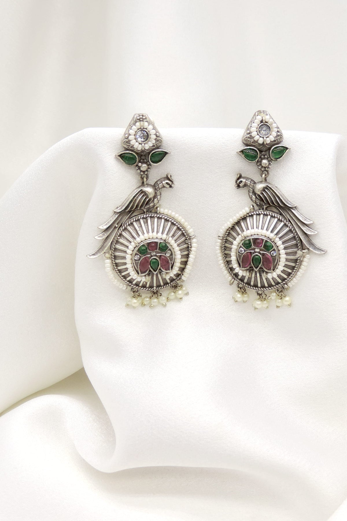 Oxidized silver peacock green pink jhumka earrings with intricate feather detailing by joyrias