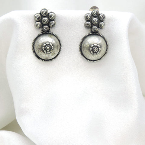 Oxidized silver floral circle drop earrings with intricate dotted detailing by joyrias