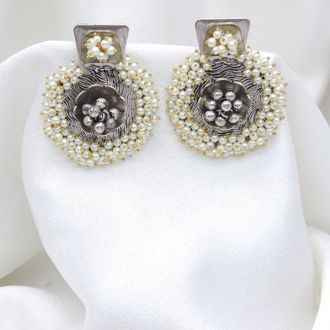 Oxidized dual-tone floral pearl stud earrings with intricate silver detailing by joyrias