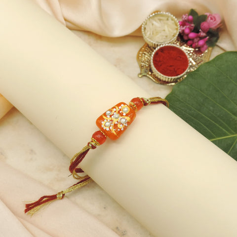 Handcrafted Orange Bead Rakhi with Crystal Floral Design