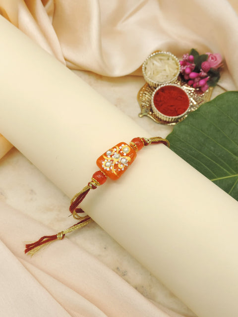Handcrafted Orange Bead Rakhi with Crystal Floral Design