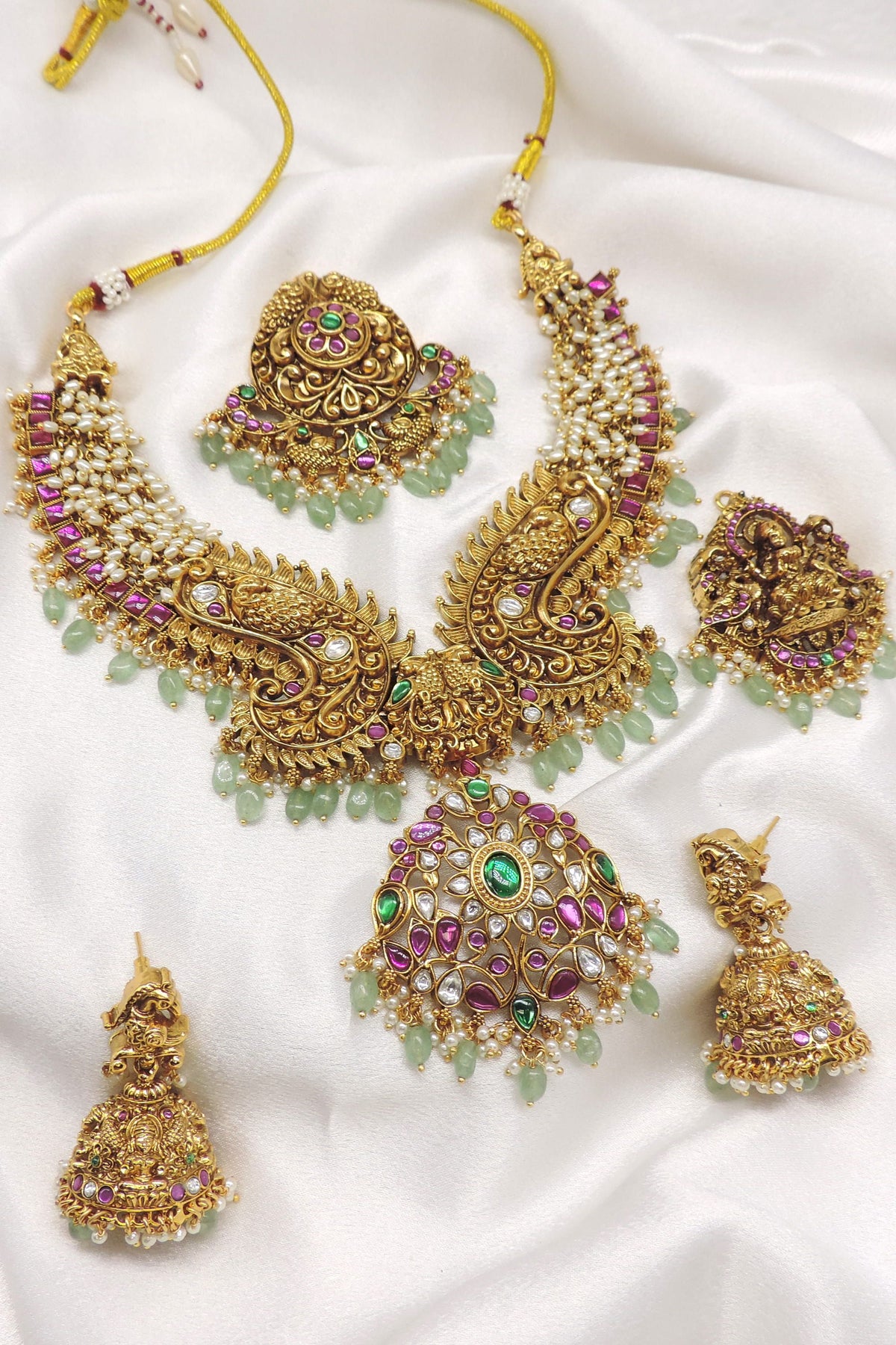 Temple gold-toned peacock Lakshmi kundan necklace set with matching earrings, maang tikka and pearl detailing by joyrias