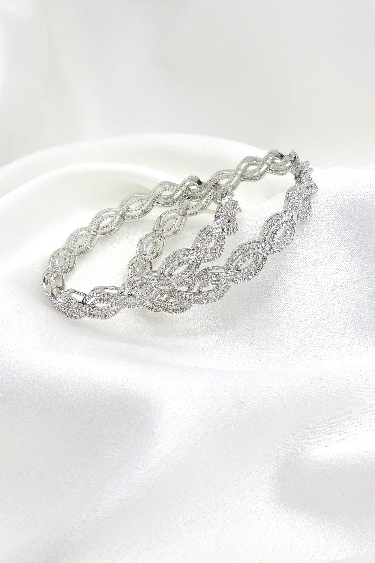 Elegant silver-toned wave AD bangle set with intricate detailing by joyrias