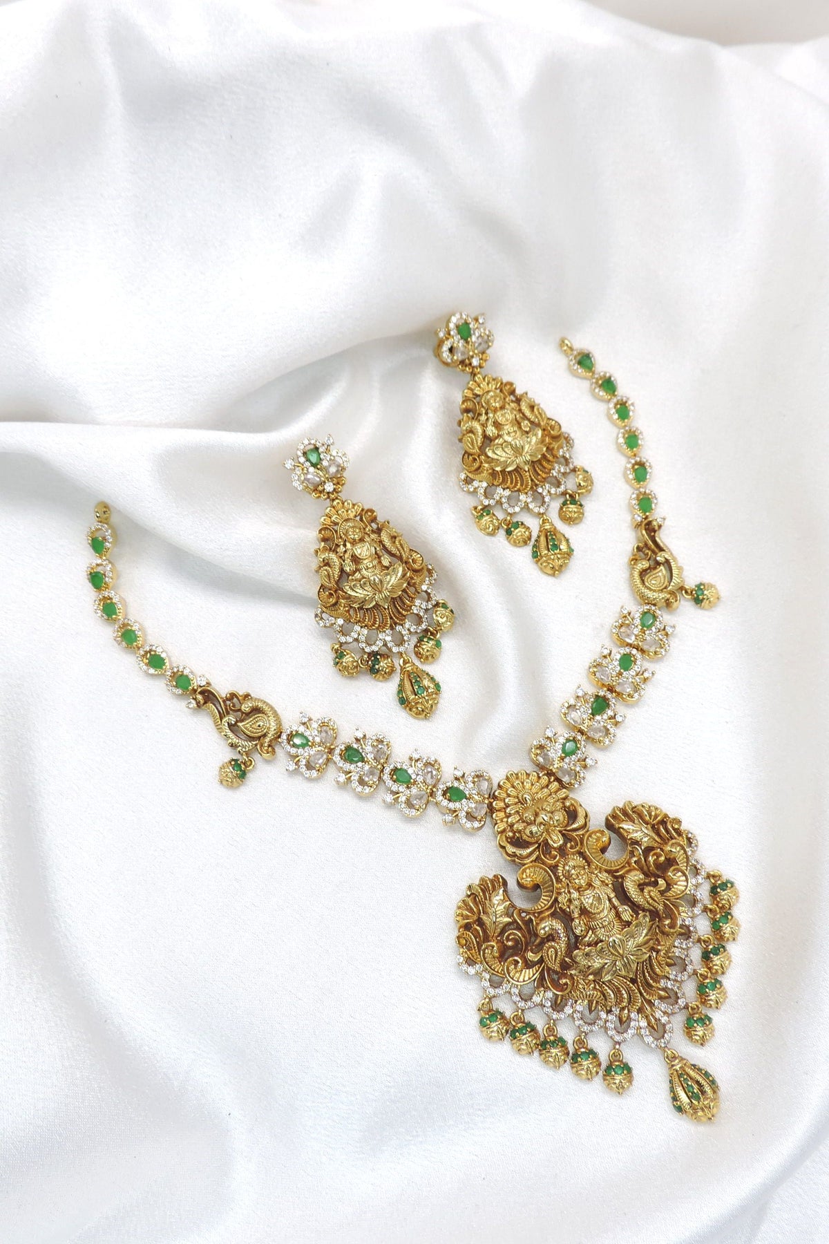Royal green kundan necklace with matching earrings and ornate gold tone detailing by joyrias