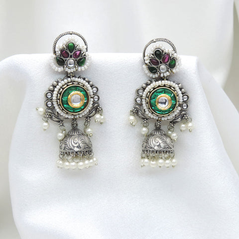 Oxidized dual-tone green floral jhumka earrings with gold-toned detailing and pearl accents by joyrias