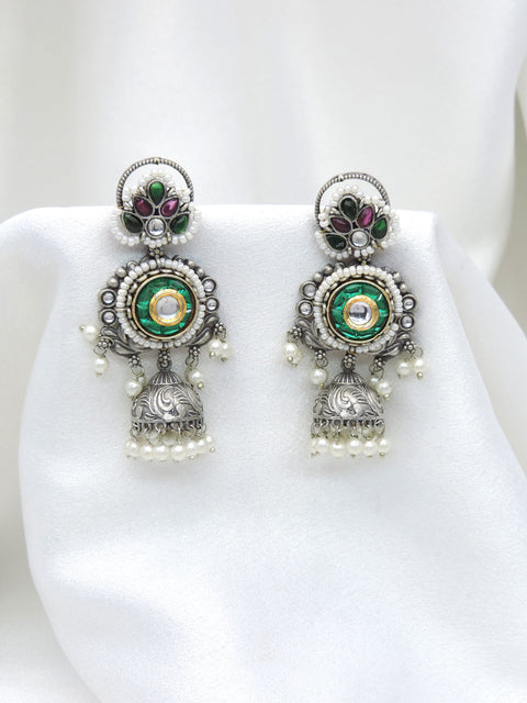 Oxidized dual-tone green floral jhumka earrings with gold-toned detailing and pearl accents by joyrias