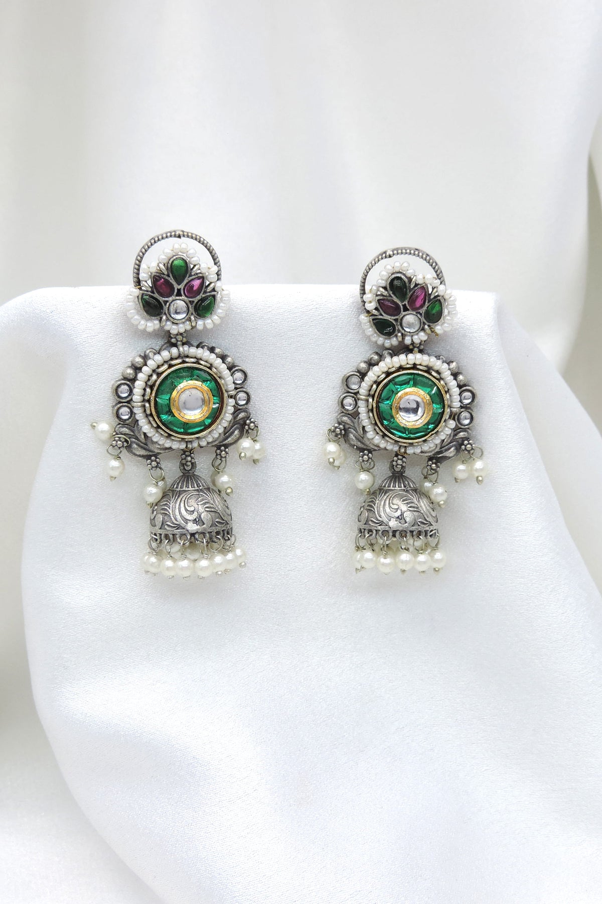 Oxidized dual-tone green floral jhumka earrings with gold-toned detailing and pearl accents by joyrias