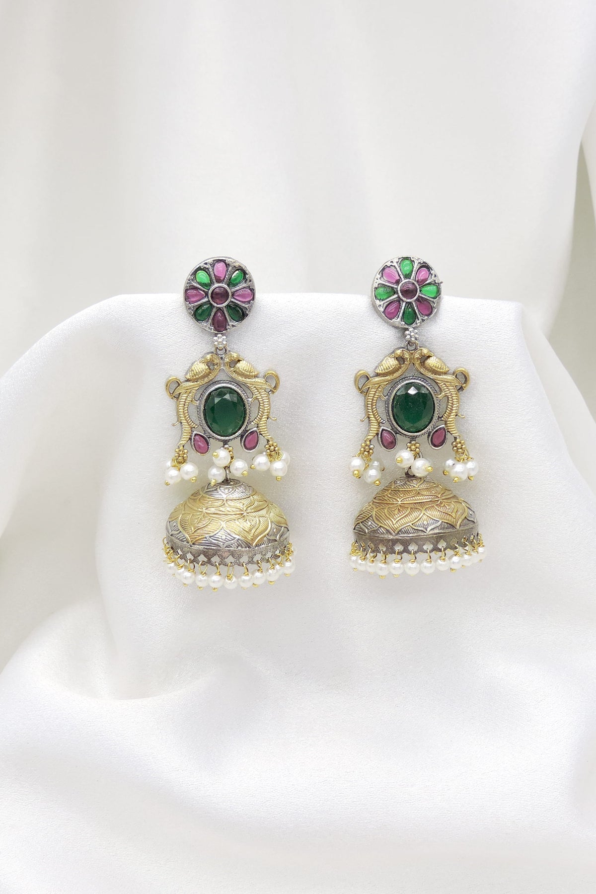 Oxidized dual-tone green stone floral jhumka earrings with gold-toned detailing and pearl fringe by joyrias