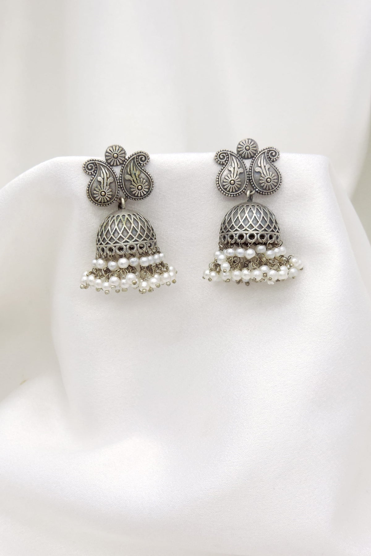 Oxidized silver floral paisley jhumka earrings with intricate dome and pearl detailing by joyrias