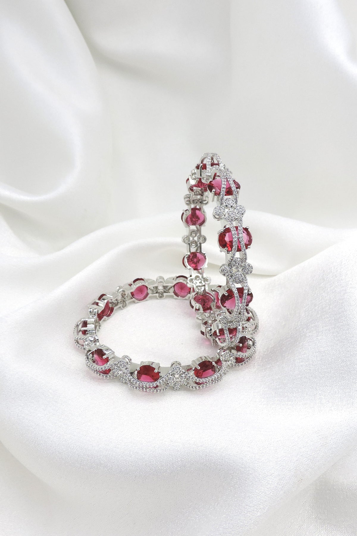 Silver-toned pink stone AD bangle set with intricate floral detailing by joyrias