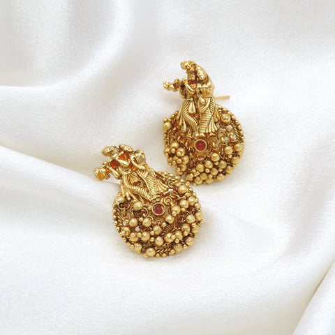 Gold-toned temple jhumka earrings with intricate traditional detailing by joyrias