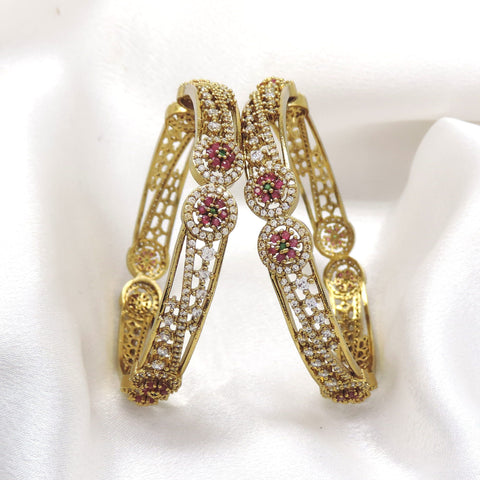 Gold-tone jali bangle pair with pink floral CZ AD accents by joyrias