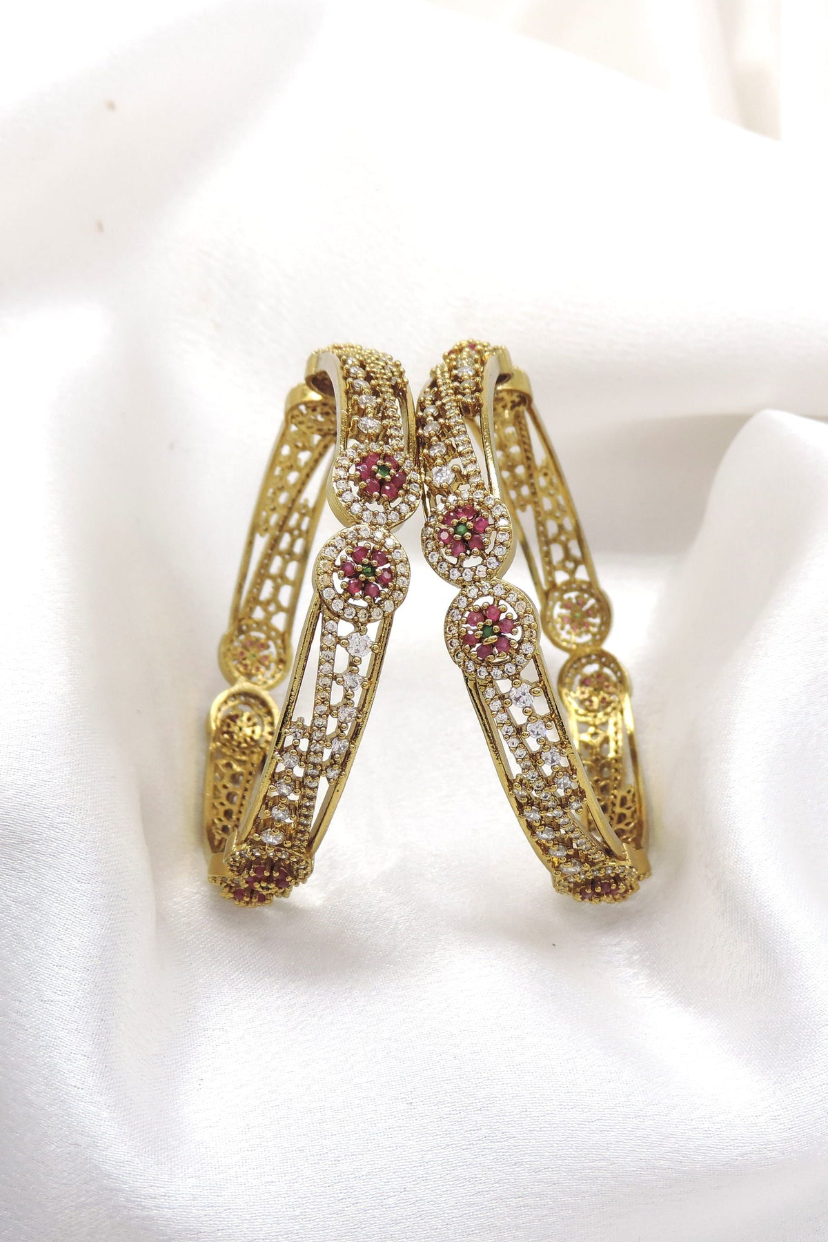 Gold-tone jali bangle pair with pink floral CZ AD accents by joyrias