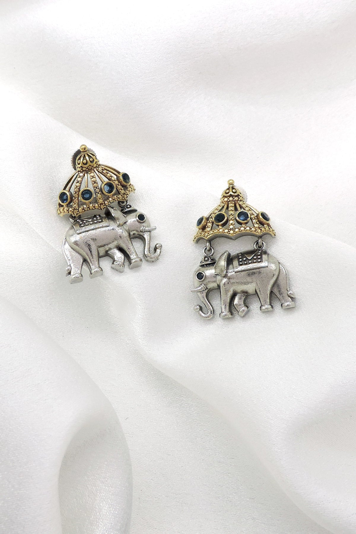 Oxidized dual-tone elephant jhumka earrings with blue stone and gold-toned detailing by joyrias