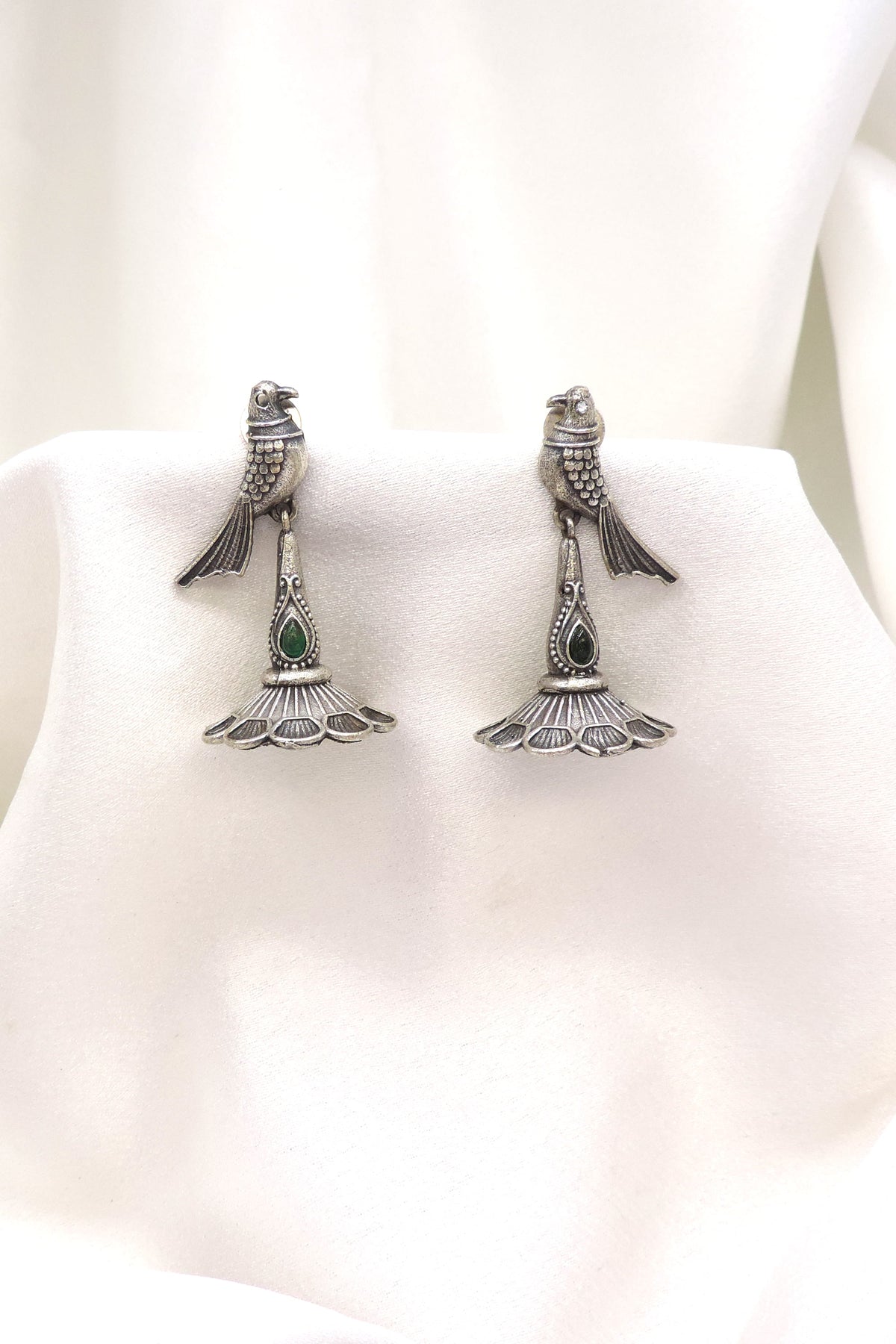 Oxidized silver peacock green stone drop earrings with detailed feather motif by joyrias