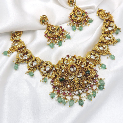 Heritage kundan polki temple necklace set with green stones, pearl detailing and matching earrings by joyrias