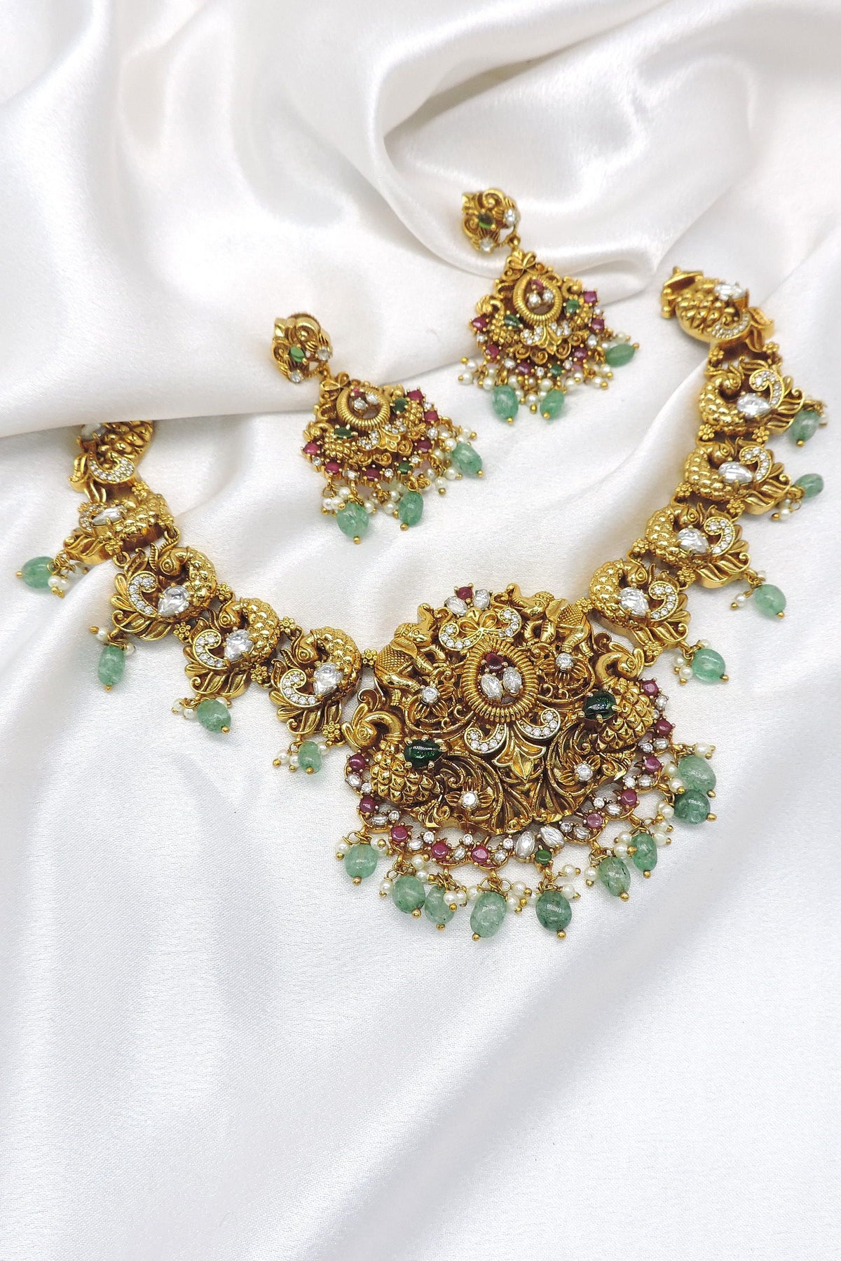 Heritage kundan polki temple necklace set with green stones, pearl detailing and matching earrings by joyrias