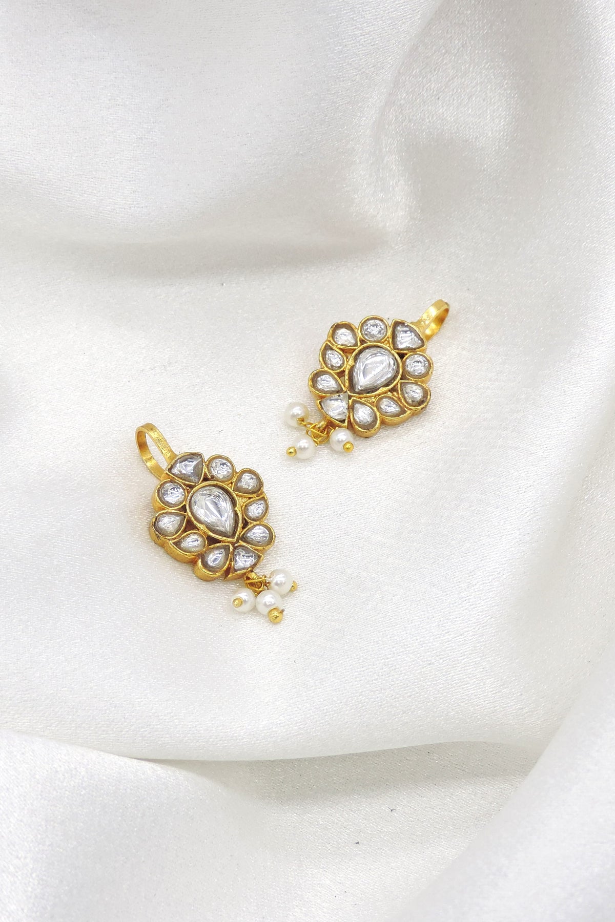 Gold-toned kundan pearl drop earrings with floral detailing by joyrias