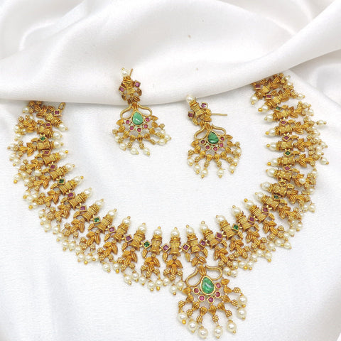 Gold-toned South Indian Guttapusalu style temple necklace set with green stones and pearl detailing by joyrias