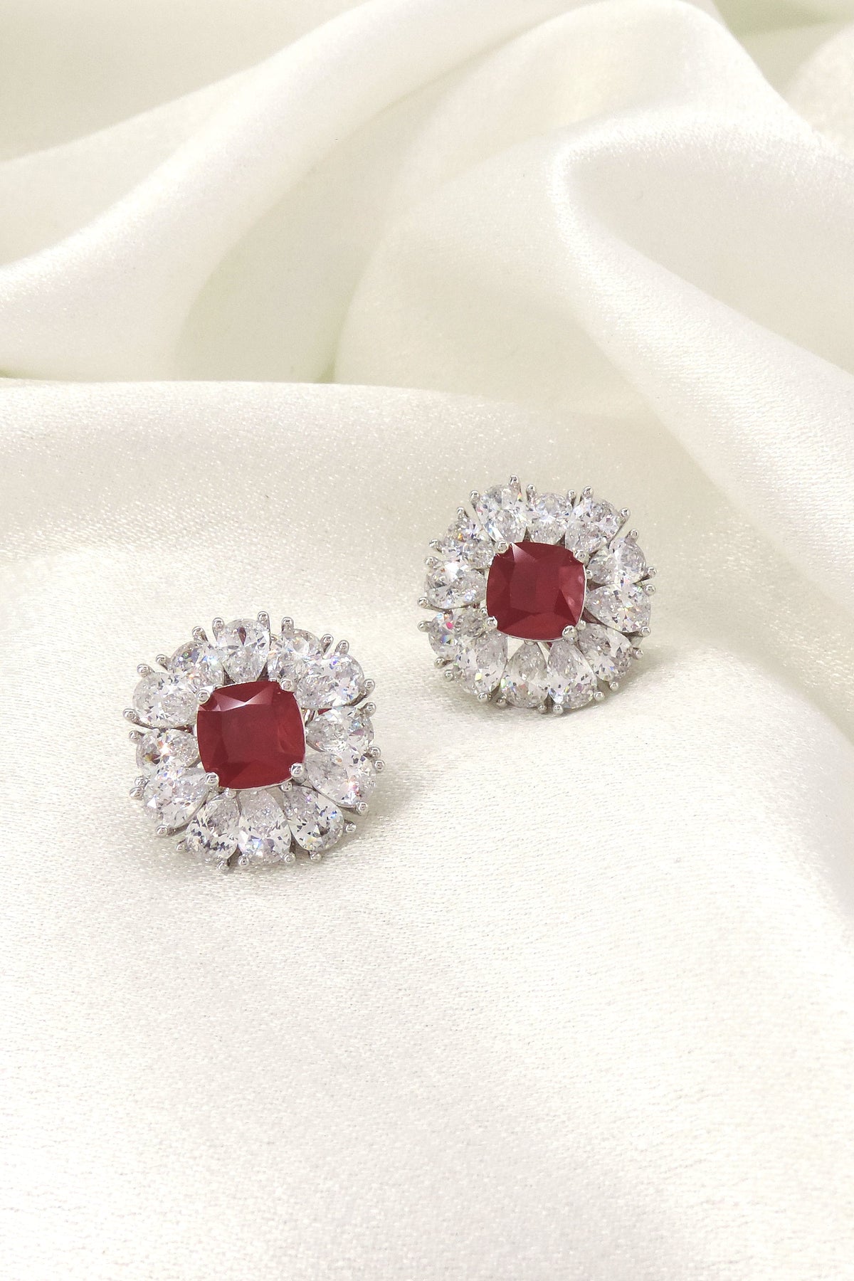 Ruby red cushion AD halo stud earrings by Joyrias