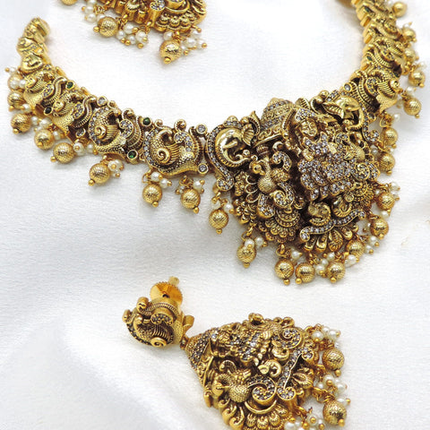 Temple gold-toned peacock goddess necklace set with matching earrings, pearls and traditional detailing by joyrias