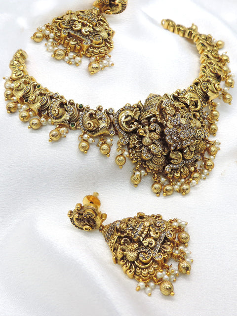 Temple gold-toned peacock goddess necklace set with matching earrings, pearls and traditional detailing by joyrias