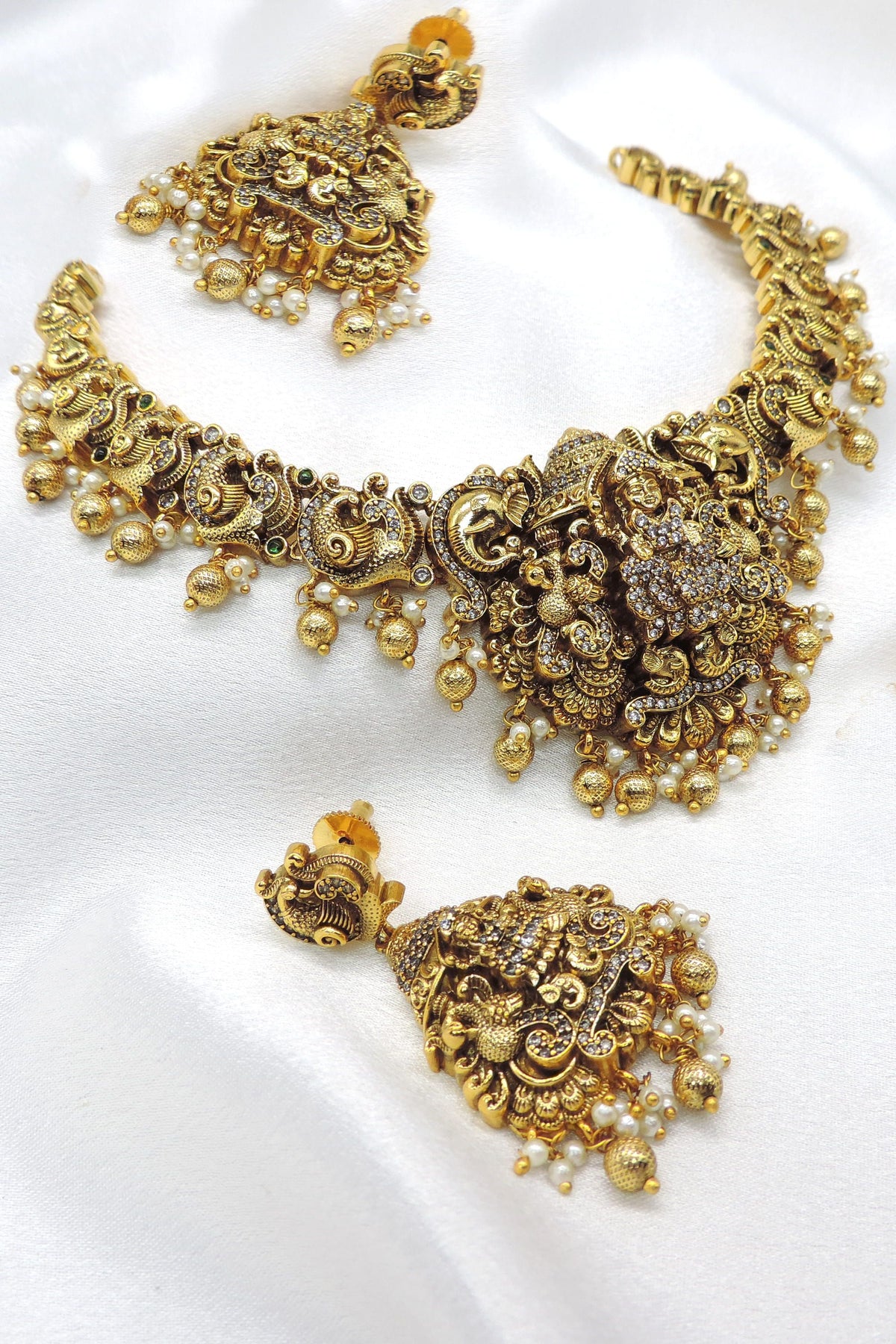 Temple gold-toned peacock goddess necklace set with matching earrings, pearls and traditional detailing by joyrias