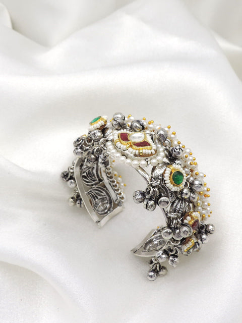 Oxidized silver multicolor temple cuff bracelet with red green stones, pearl detailing, and dangling silver charms by joyrias