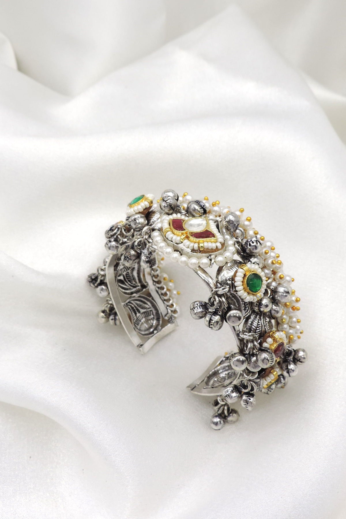 Oxidized silver multicolor temple cuff bracelet with red green stones, pearl detailing, and dangling silver charms by joyrias