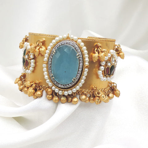 Gold-toned blue stone pearl cuff bracelet with colorful side detailing and dangling charms by joyrias