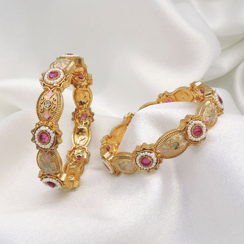 Gold-toned pink stone AD pearl bangle set with intricate floral detailing by joyrias