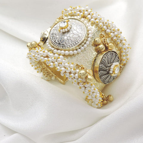 Gold-toned silver pearl floral cuff bracelet with ornate detailing and dangling golden charms by joyrias