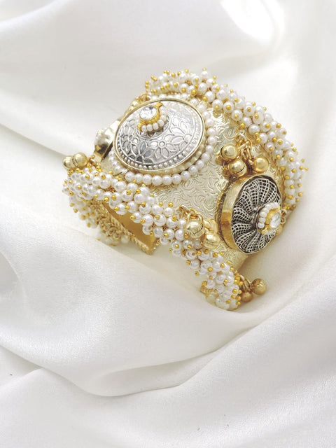 Gold-toned silver pearl floral cuff bracelet with ornate detailing and dangling golden charms by joyrias