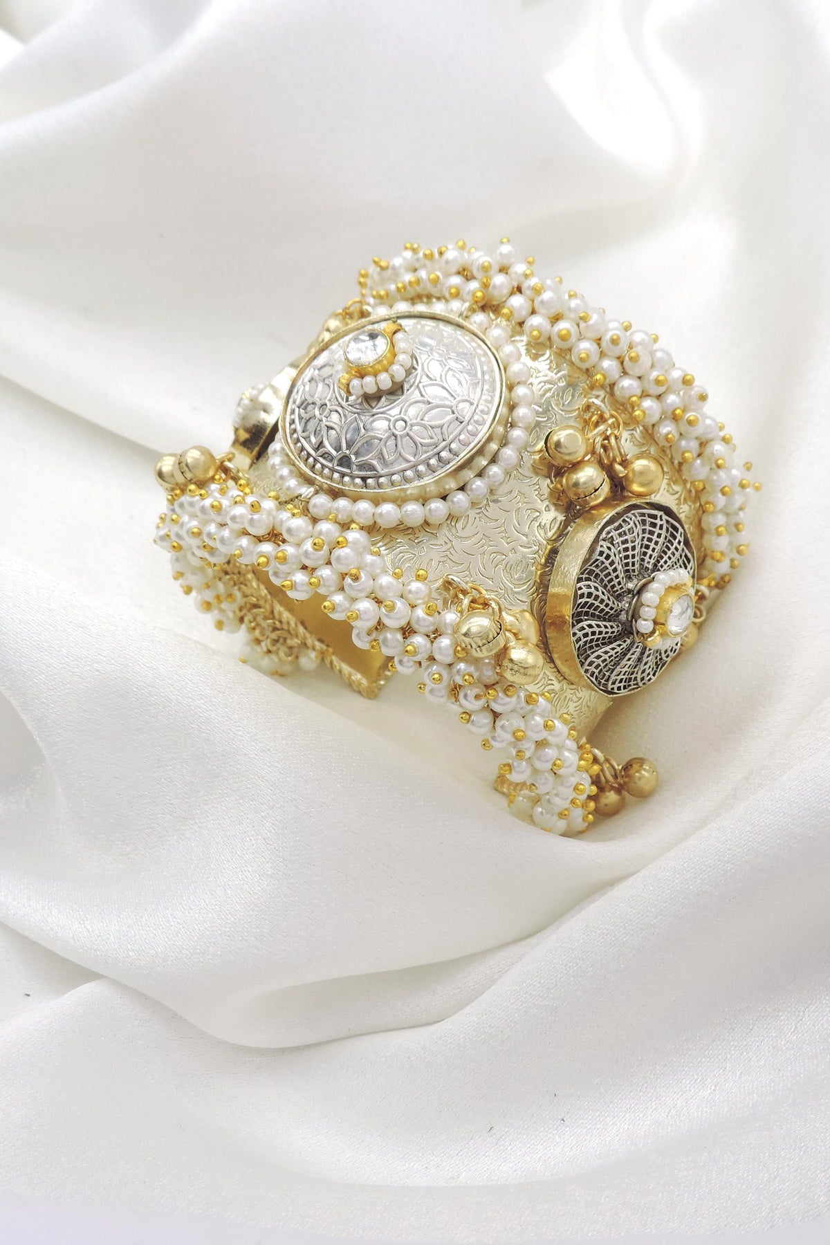 Gold-toned silver pearl floral cuff bracelet with ornate detailing and dangling golden charms by joyrias