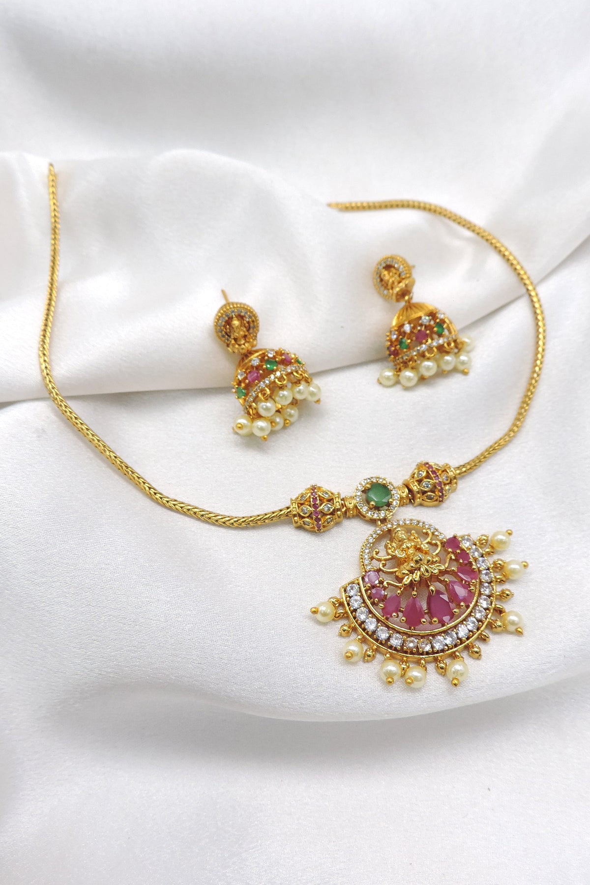 Antique ruby emerald temple necklace set with Lakshmi pendant, pearl detailing and matching jhumka earrings by joyrias