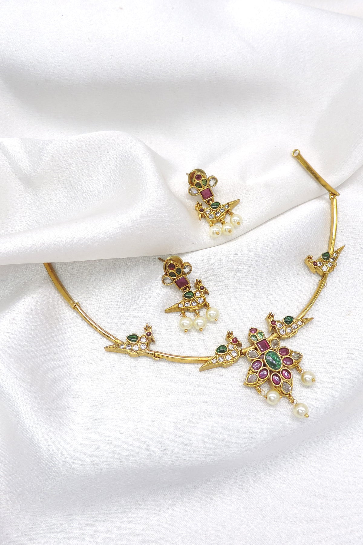 Inspire temple style gold-toned peacock choker necklace set with colorful stones, pearl detailing and matching earrings by joyrias