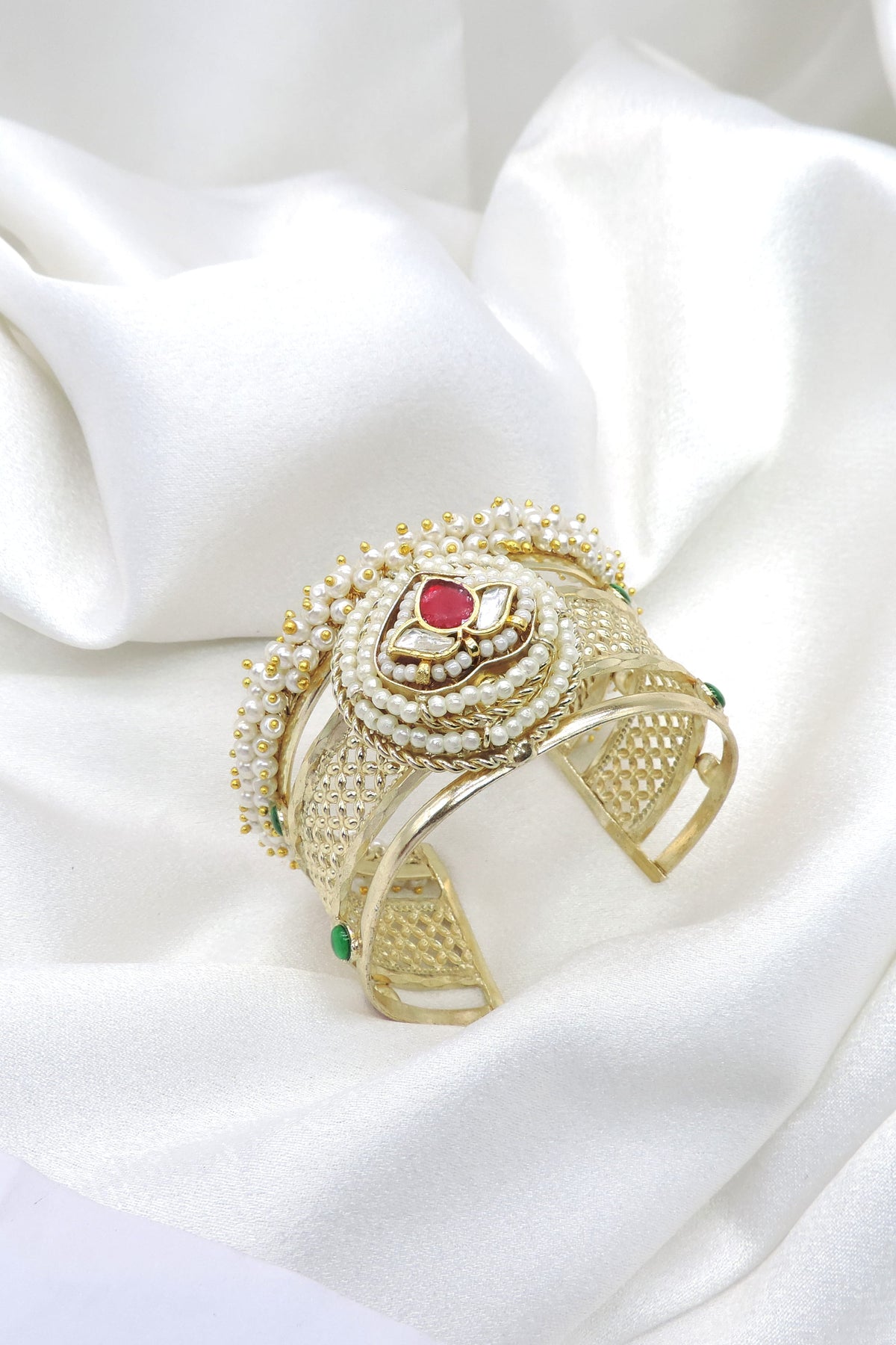 Gold-toned green maroon Kundan pearl cuff bracelet with floral detailing and intricate traditional accents by joyrias