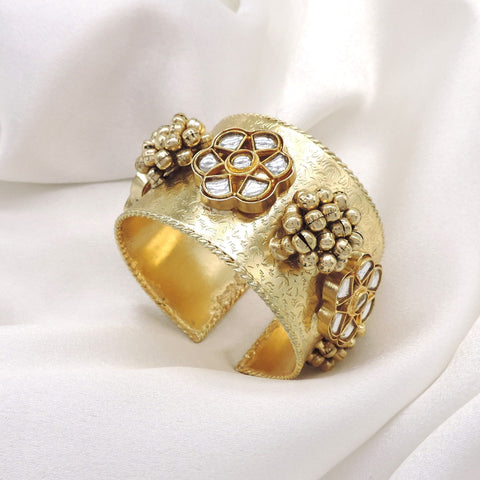 Gold-toned floral Kundan pearl cuff bracelet with intricate engraved detailing and traditional bead accents by joyrias