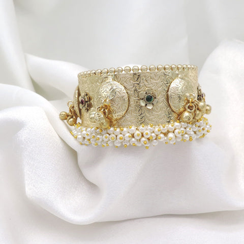 Gold-toned green pearl floral cuff bracelet with intricate engraved detailing and dangling charms by joyrias