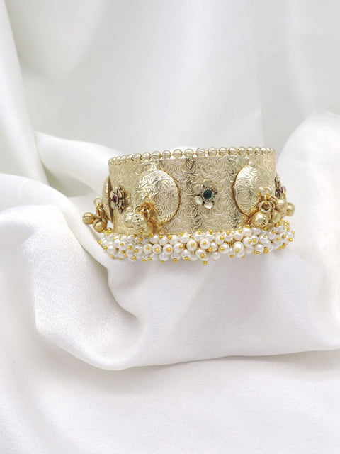Gold-toned green pearl floral cuff bracelet with intricate engraved detailing and dangling charms by joyrias