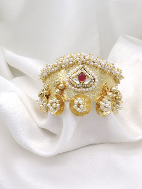 Gold-toned maroon pearl floral cuff bracelet with intricate traditional detailing and dangling charms by joyrias