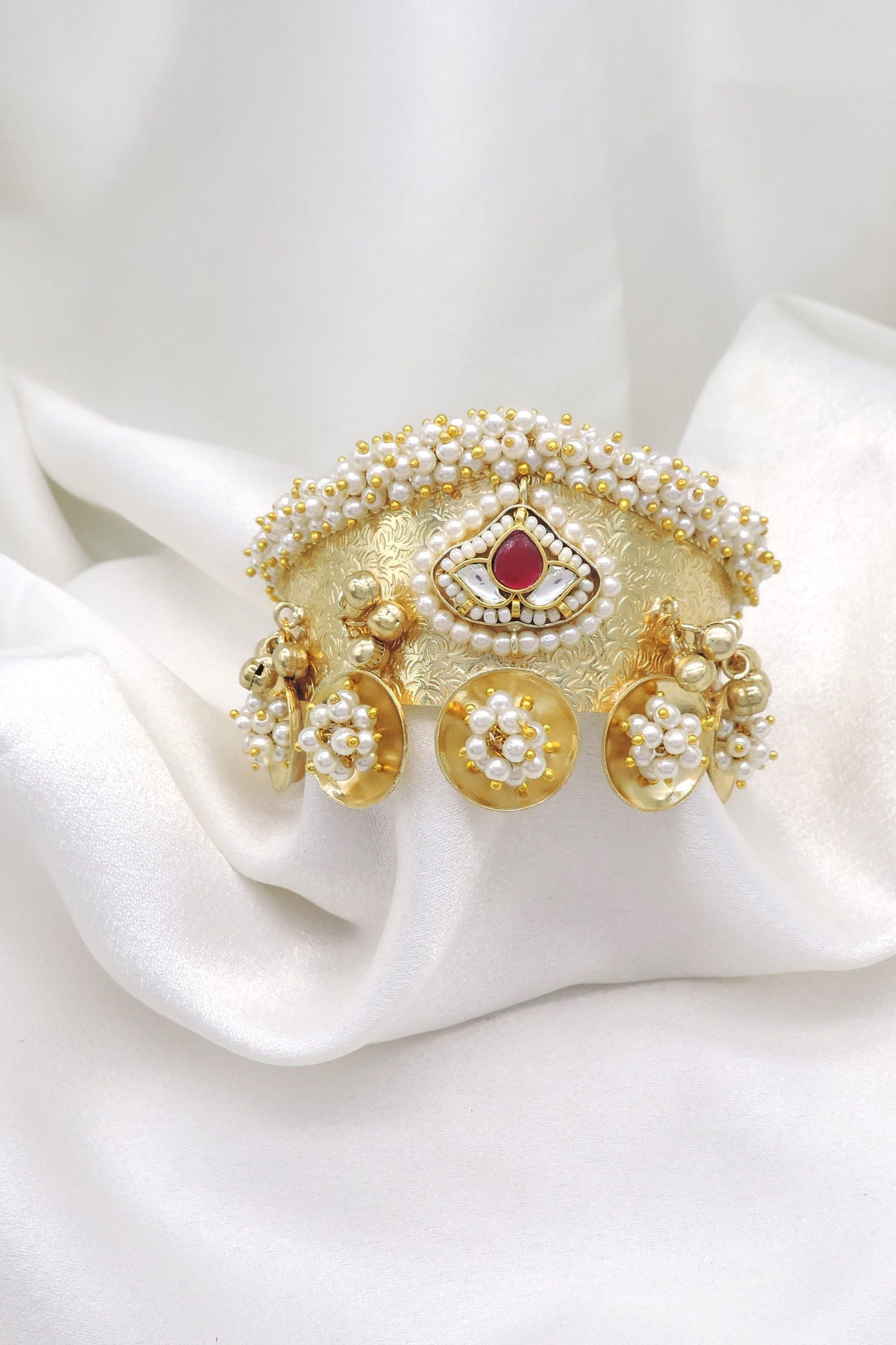 Gold-toned maroon pearl floral cuff bracelet with intricate traditional detailing and dangling charms by joyrias