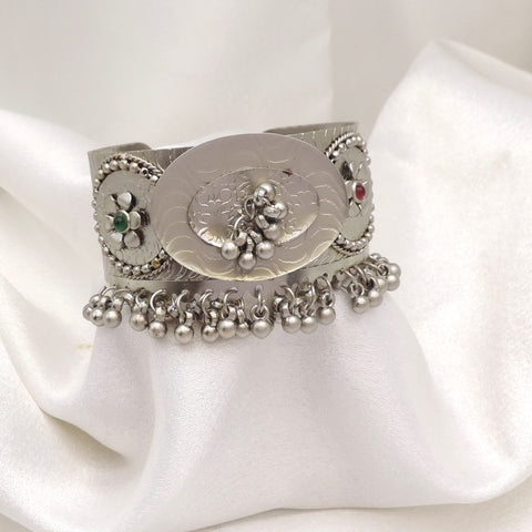 Oxidized silver floral ghungroo cuff bracelet with engraved detailing, colorful stone accents, and dangling silver charms by joyrias