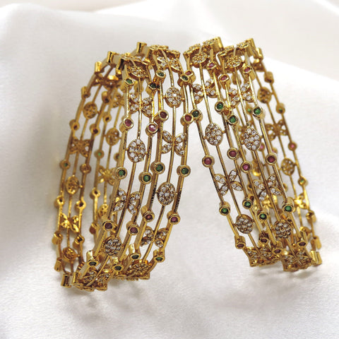 Emerald CZ ruby bangle set with floral motifs and sparkling accents by joyrias