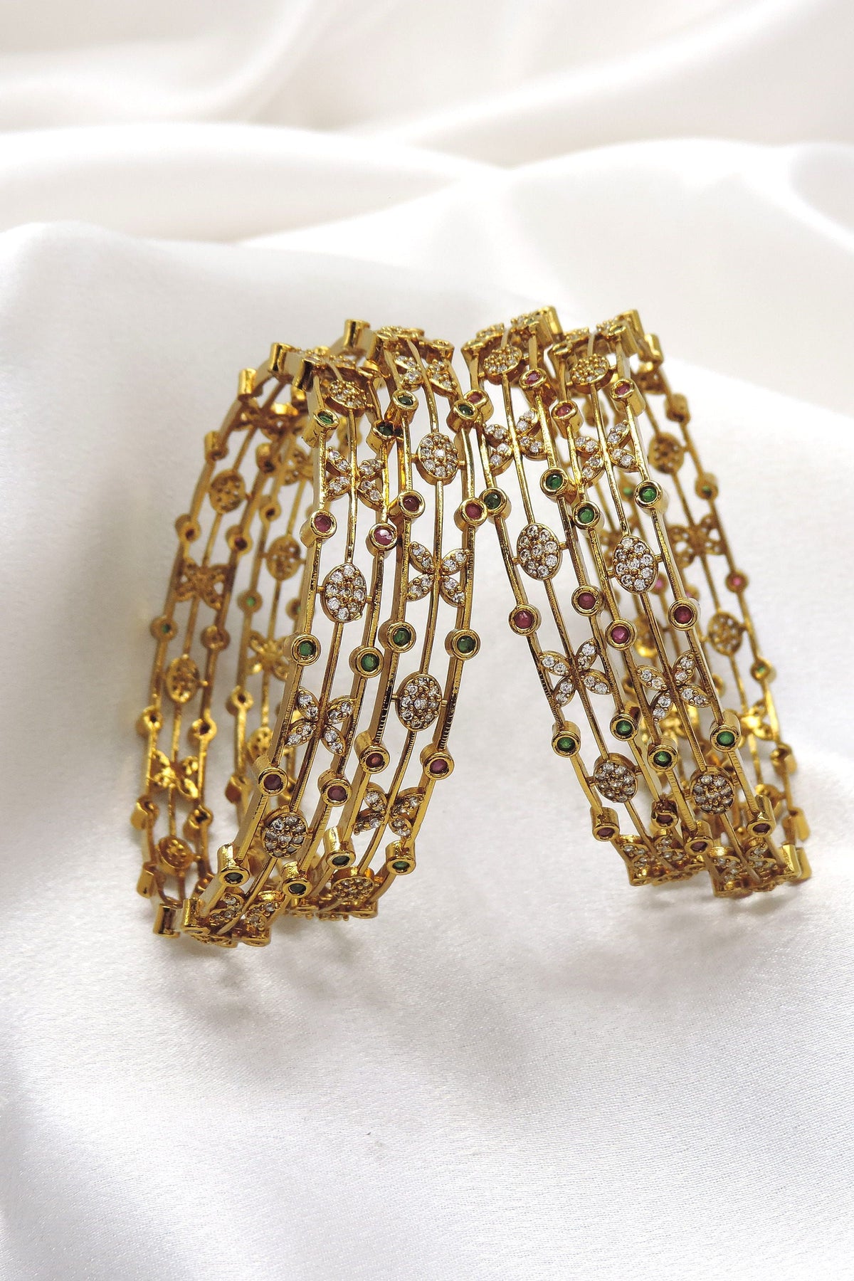 Emerald CZ ruby bangle set with floral motifs and sparkling accents by joyrias